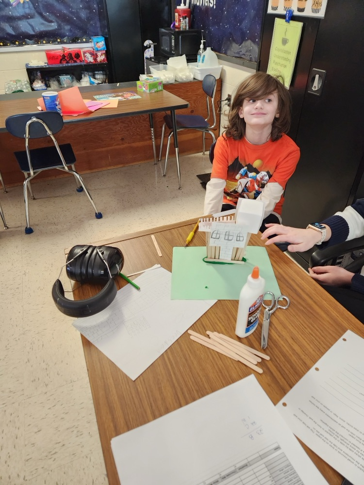 student building with popsicle sticks, glue, and clay