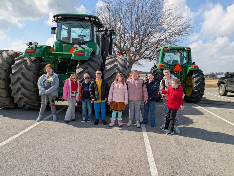 students in front of tractor