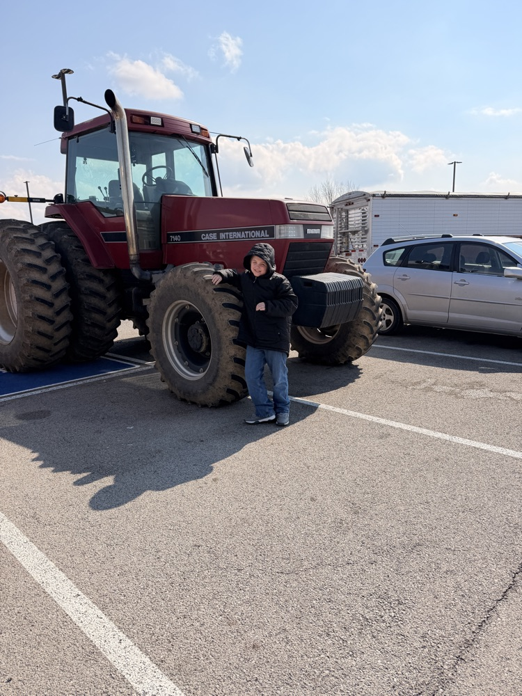 student in front of tractor