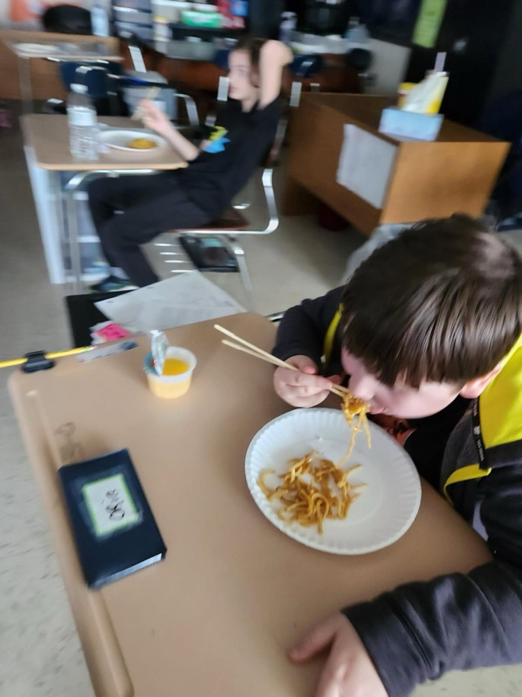 student using chopsticks to eat