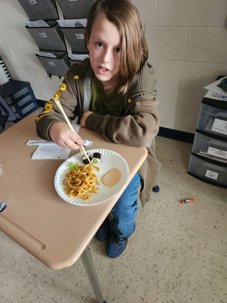 student using chopsticks to eat