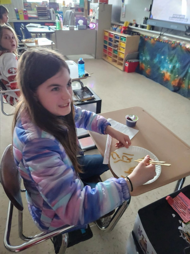 student using chopsticks to eat