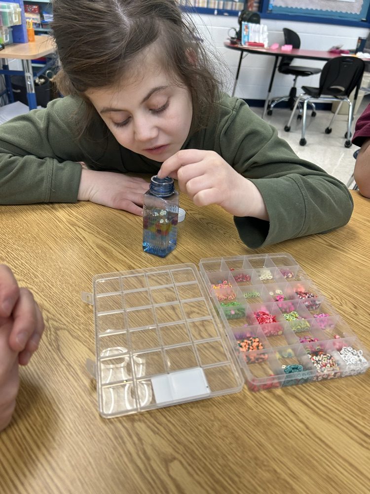 student putting beads in jar