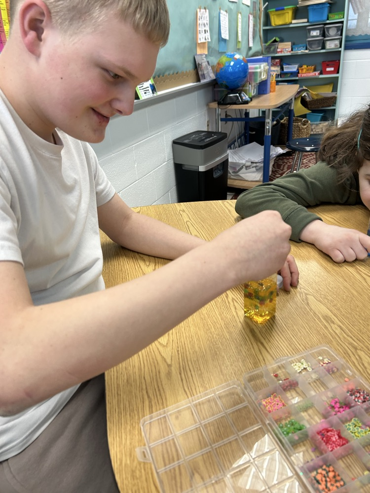 student putting beads in jar