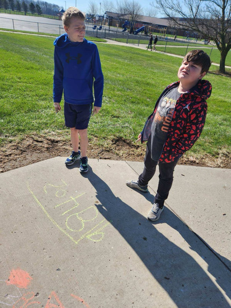 students outside practicing math using sidewalk chalk