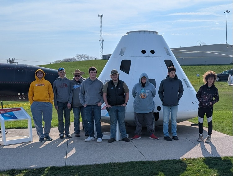 students in front of rocket