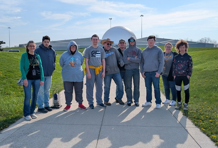 students in front of rocket