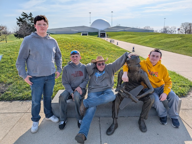 students sitting with statue