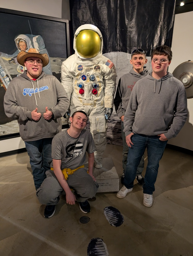 students in front of space costume