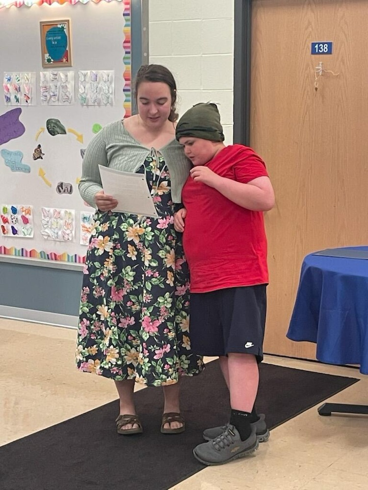 student standing with teacher