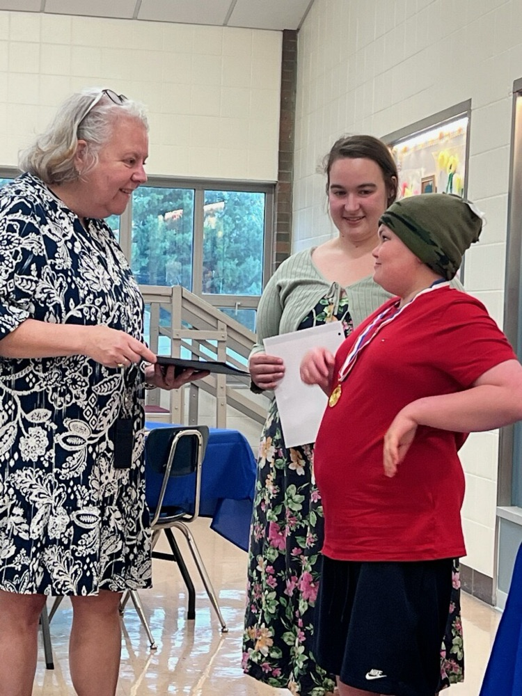 student standing with principal and teacher
