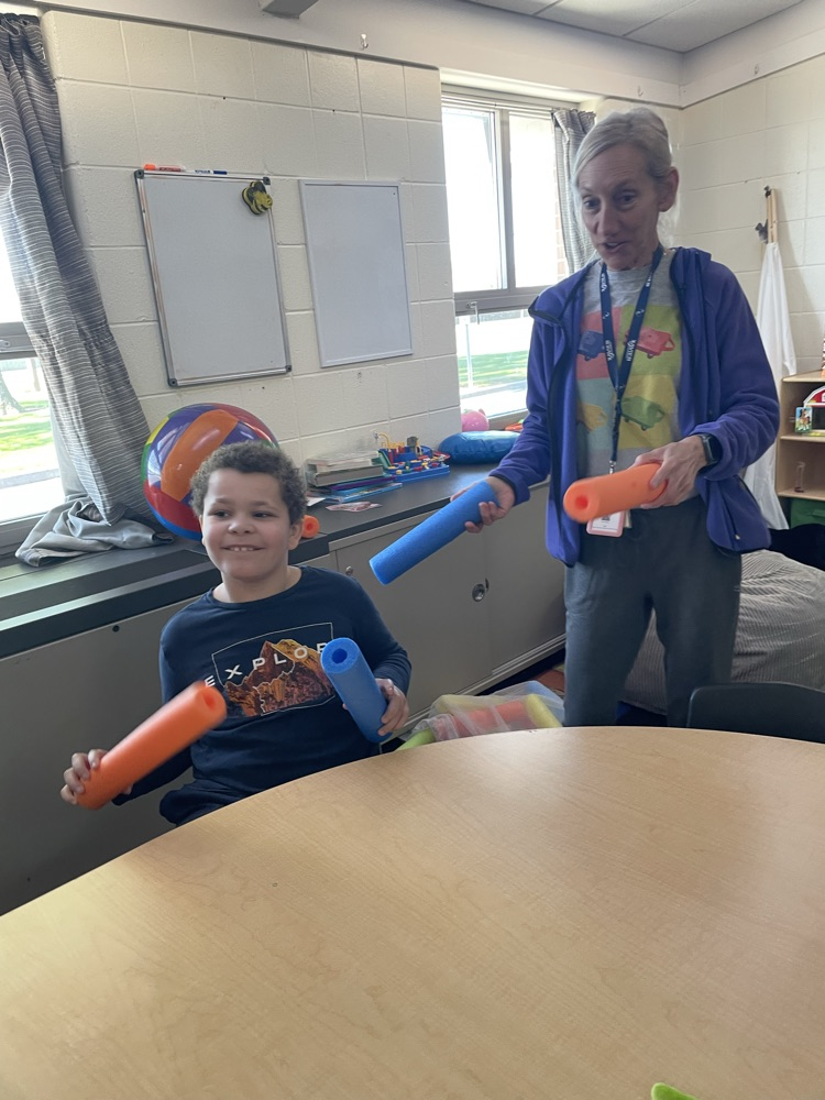 student and teacher with pool noodles