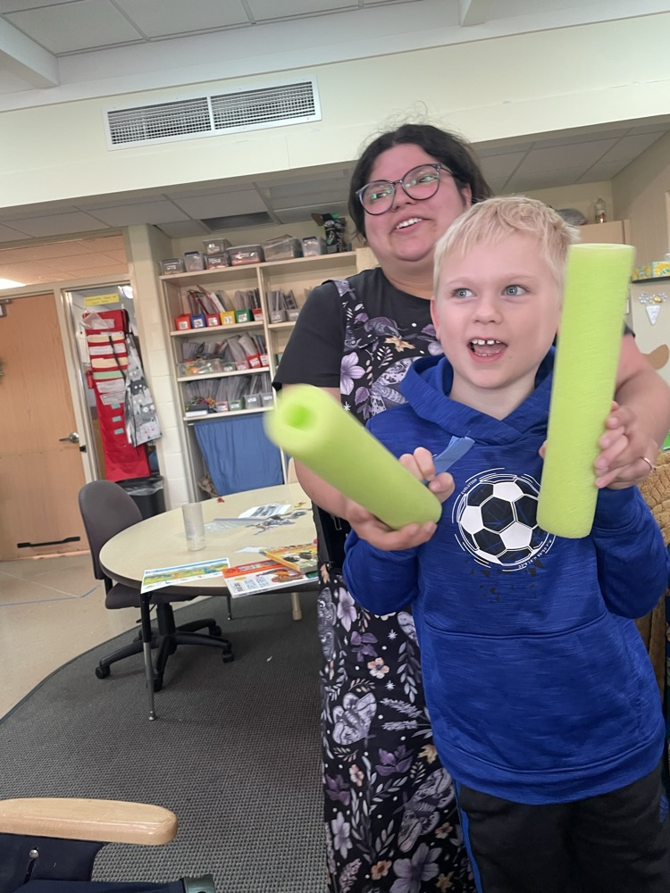 student and teacher drumming with pool noodles