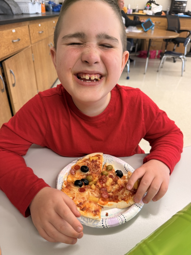 student with the pizza they made