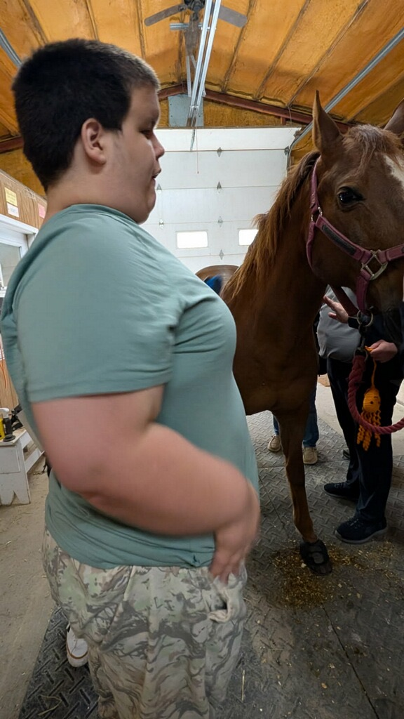 boy standing beside horse