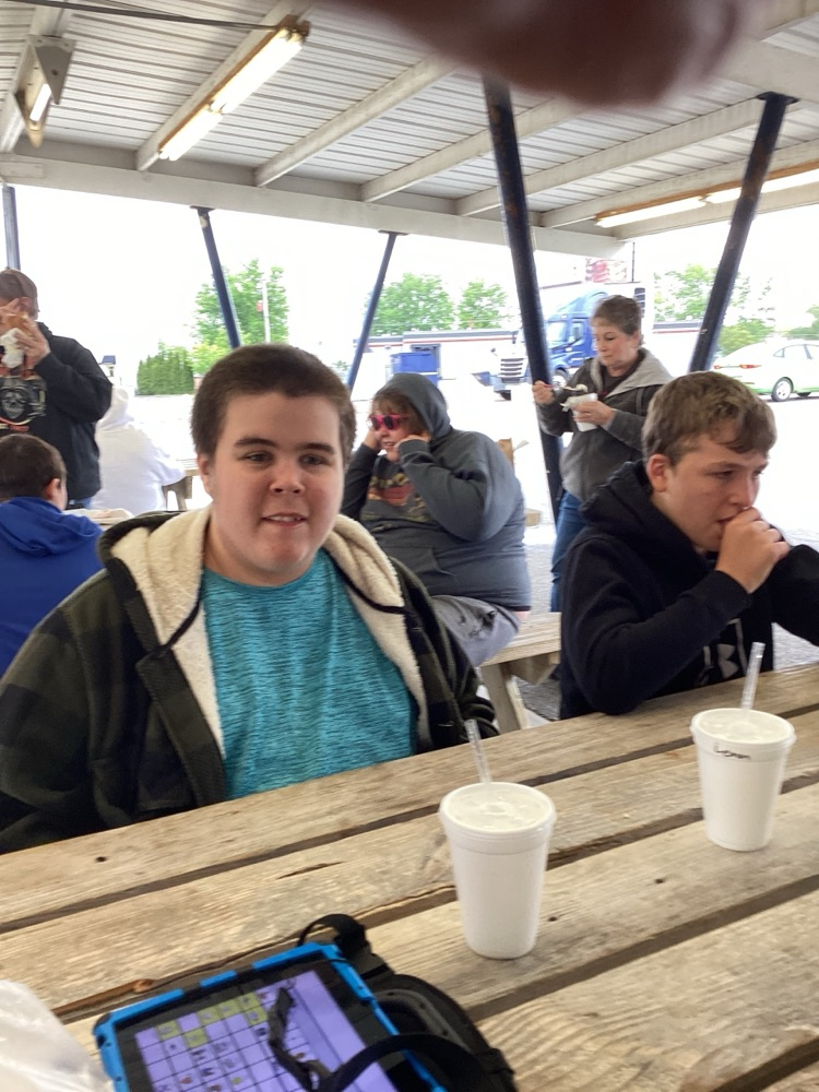 boys eating sitting at picnic table