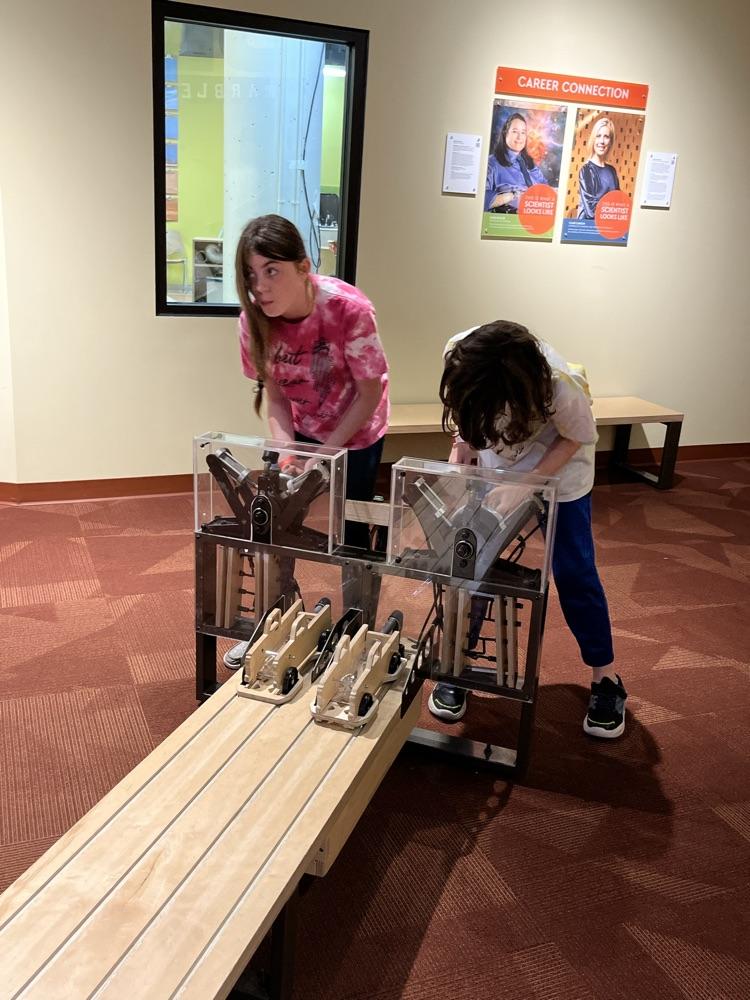 students racing wooden cars