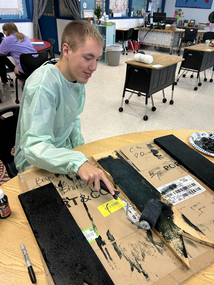 student painting wood