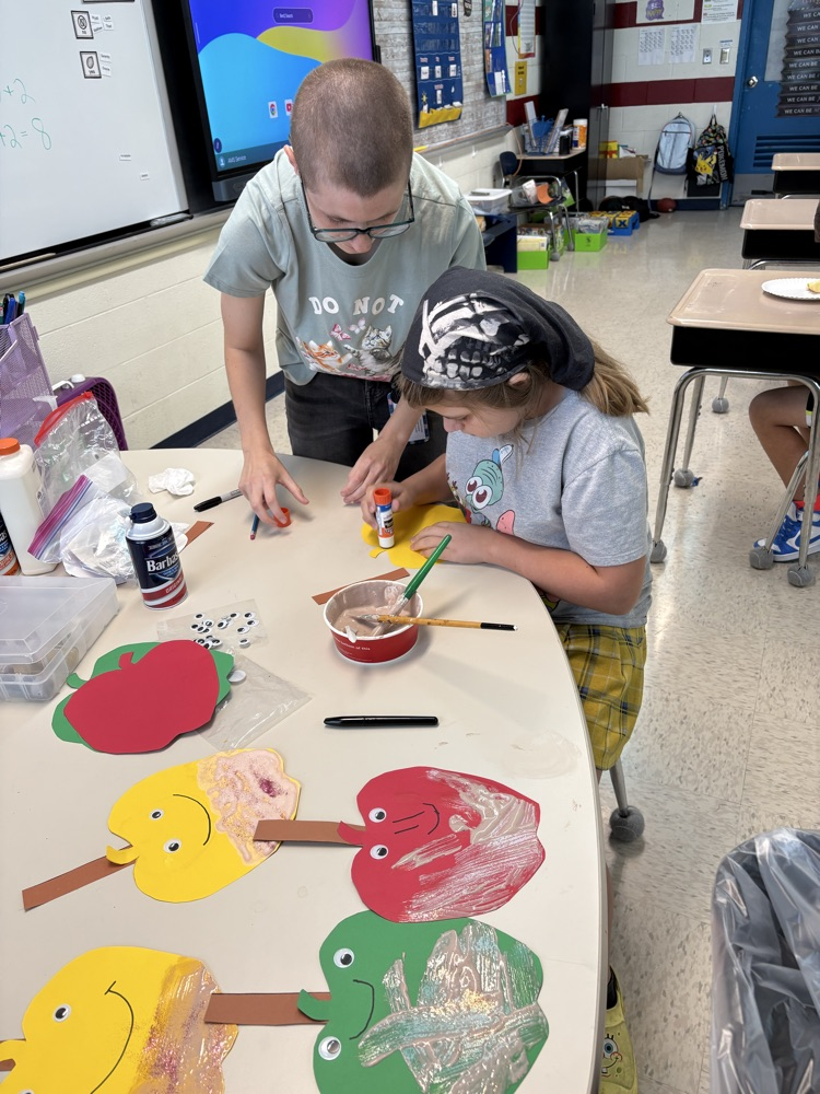 students painting apples