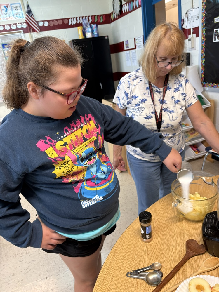 student putting sugar on apples