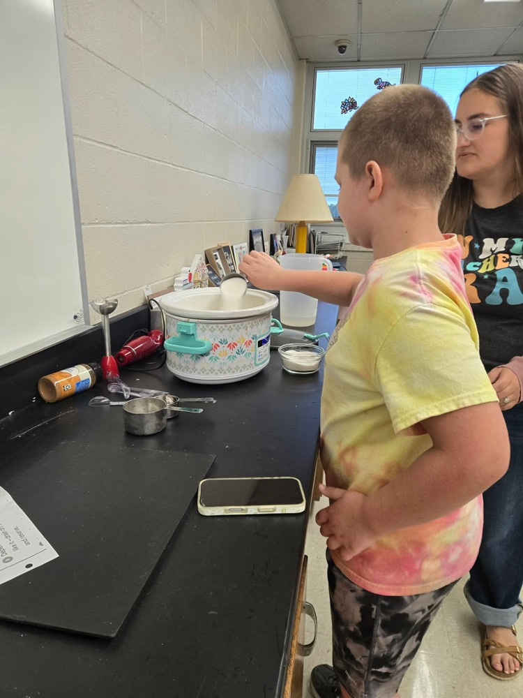 student adding sugar to applesauce