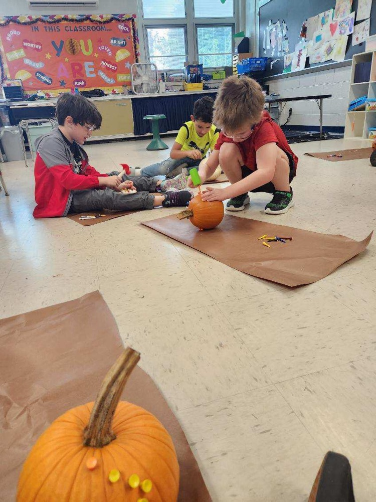 students hammering tees into pumpkin 
