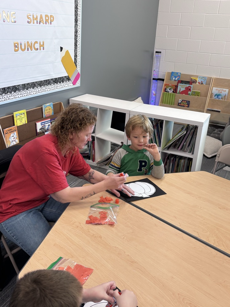 student doing a craft with grandparent