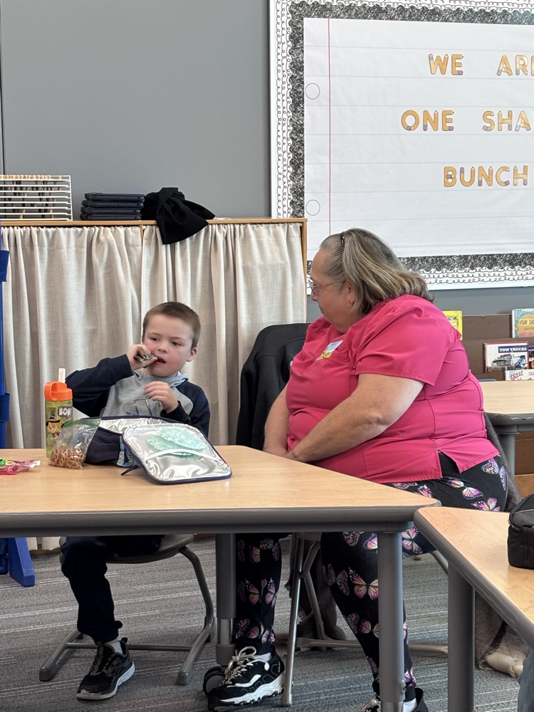 student eating lunch  with grandparent