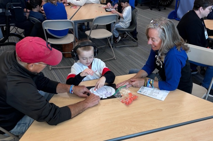student doing a craft with grandparent