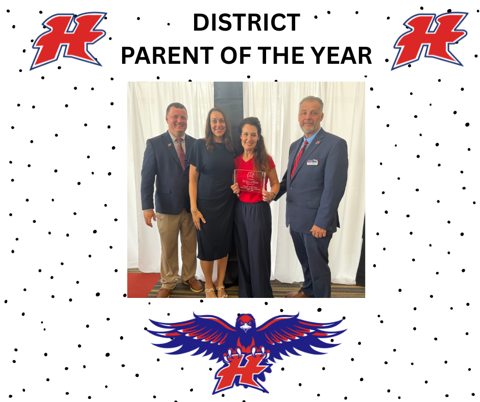 Two men in navy jackets and a woman with a blue dress, and another woman with a red shirt and navy pants  holding a plaque.