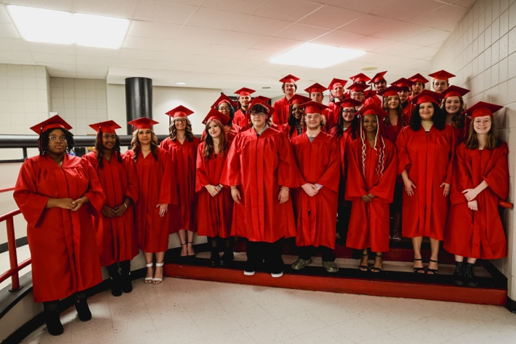 27 seniors in red caps and gowns 