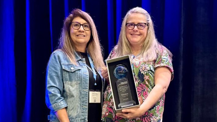 Data Processing Coordinators Chris Gilliard and Olivia Blas with the award