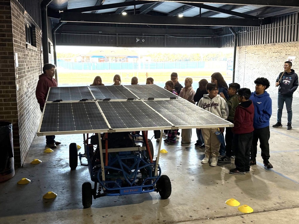 students with a giant solar panel