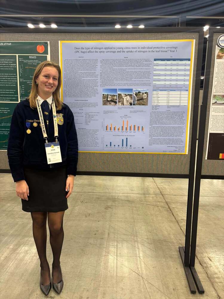 student standing next to her award-winning project