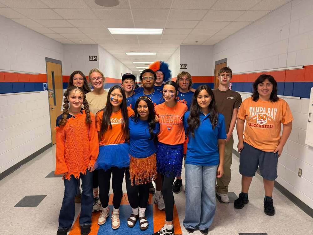 a group of hjh students wearing orange and blue