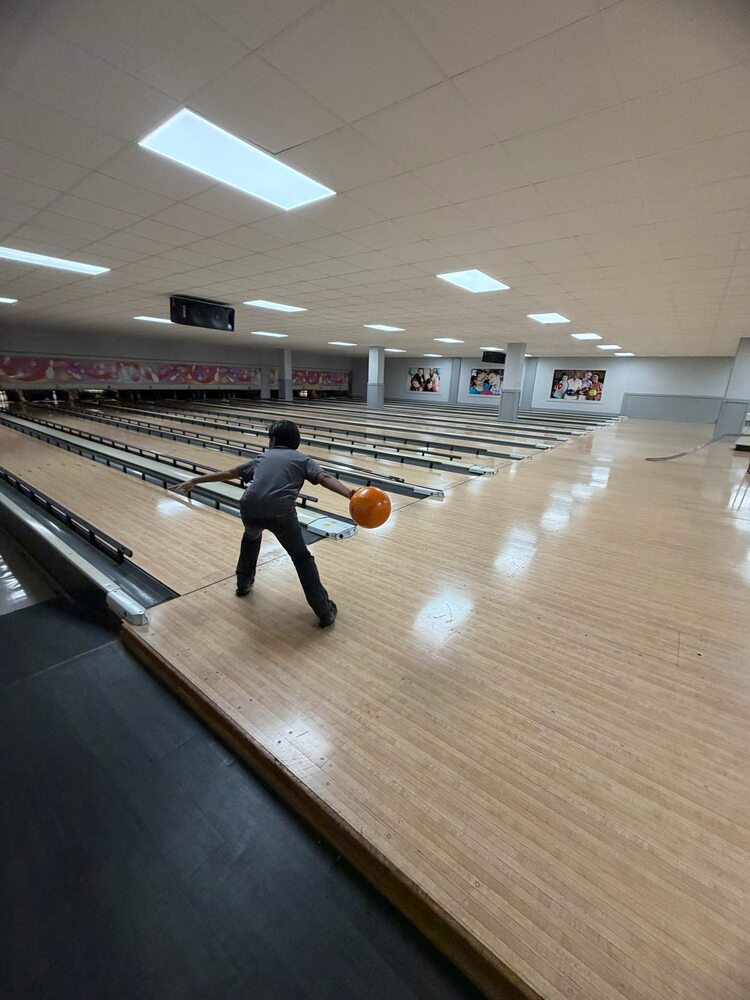 A student winds up to throw a bowling ball down the lane