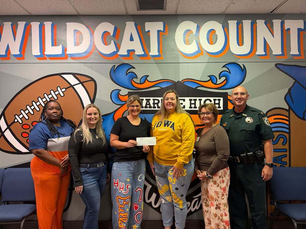 group of adults holding a check