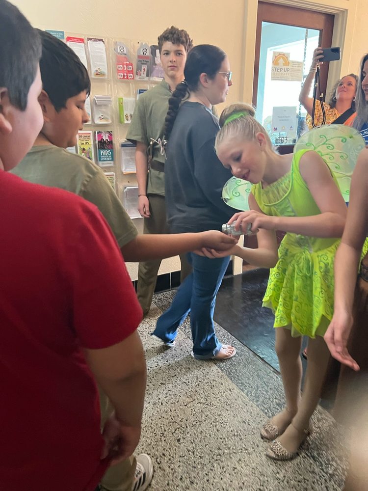 students getting a dash of "pixie dust" from Tinkerbell