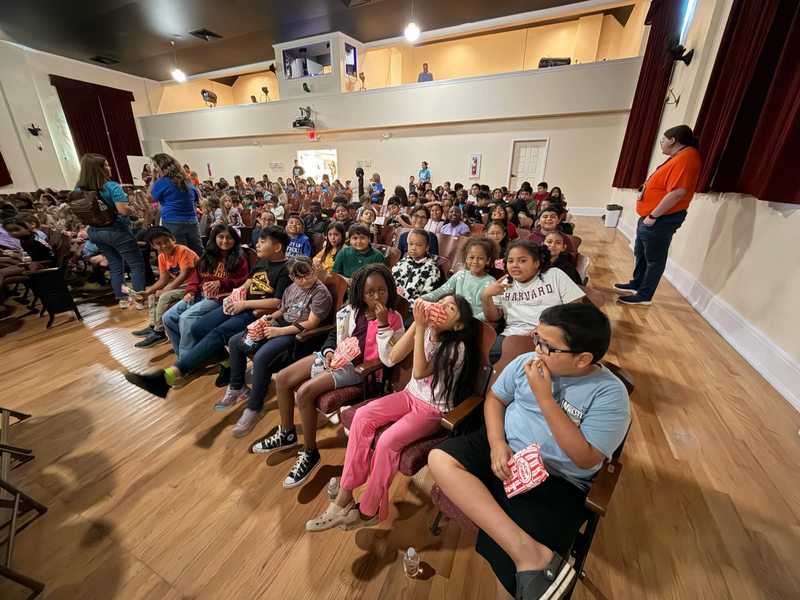 students in auditorium seating waiting for a play to start