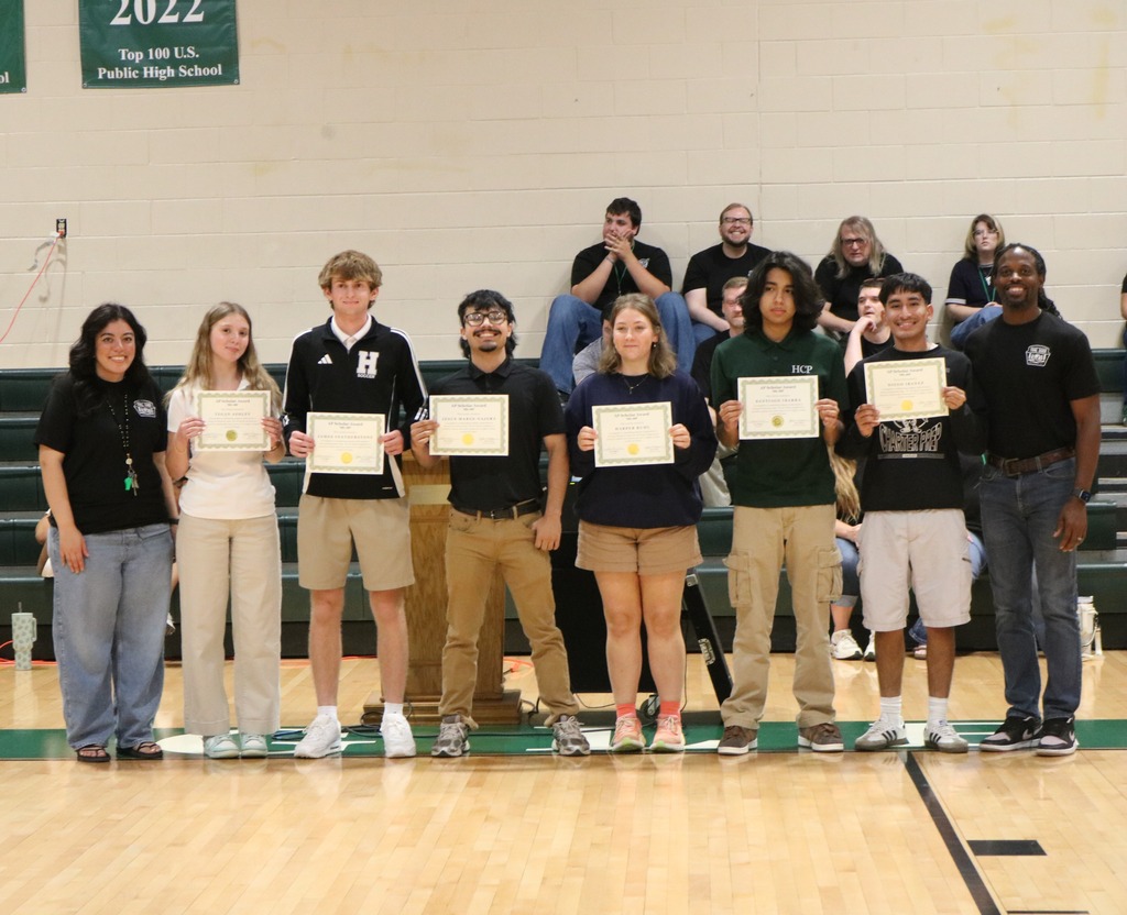 A group of AP Scholars holding certificates in a gymnasium next to their High School Principal and Assistant Principal.