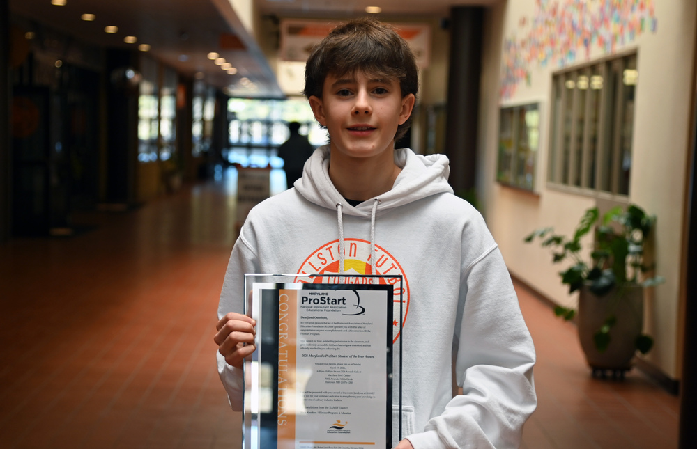 Young male student in a grey hoody holding a ProStart certificate