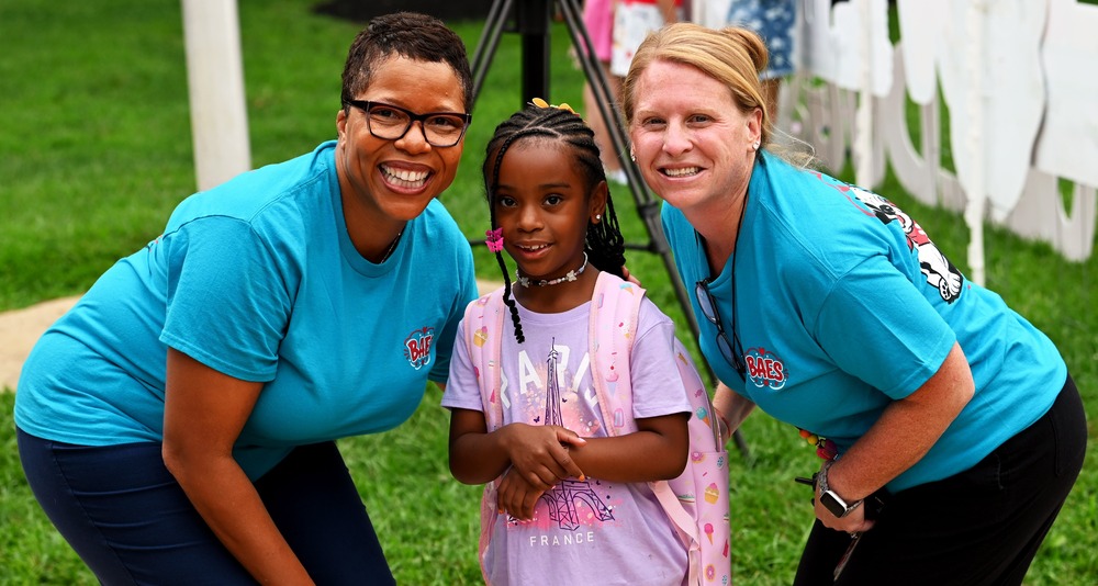 Dr Mack poses with a student and another Bel Air Elementary School student for a photo.