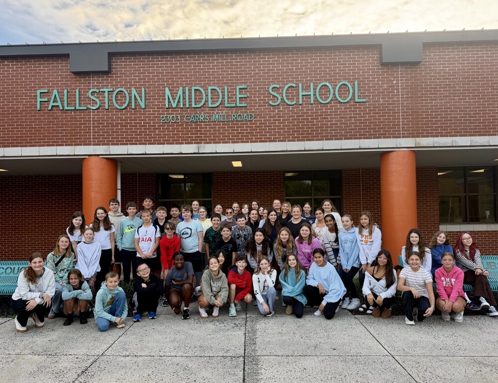 A picture of students in front of the school