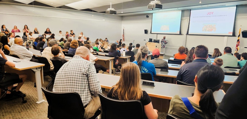 Room full of adults and children listen to presentation