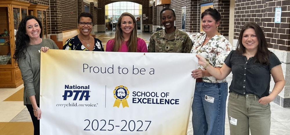 Group of adults holding a proud to be a national PTA school banner