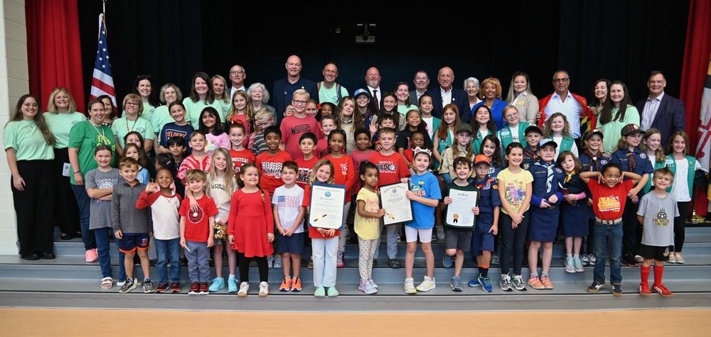 Students and staff pose with politicians on the stage after the ceremony