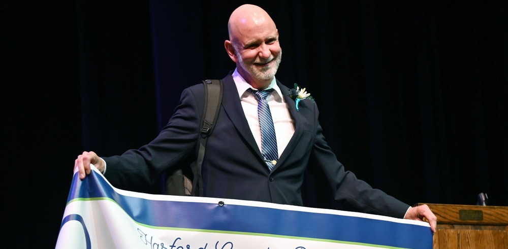 Michael James holds up teacher of the year banner