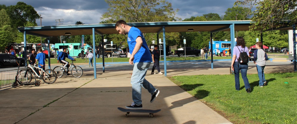 Man on a skateboard wearing jeans and a blue shirt