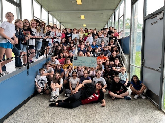 Students pose with donation check