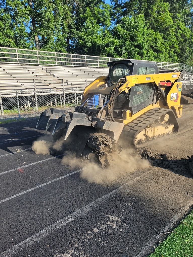 Heavy machinery tears up the old track at a high school